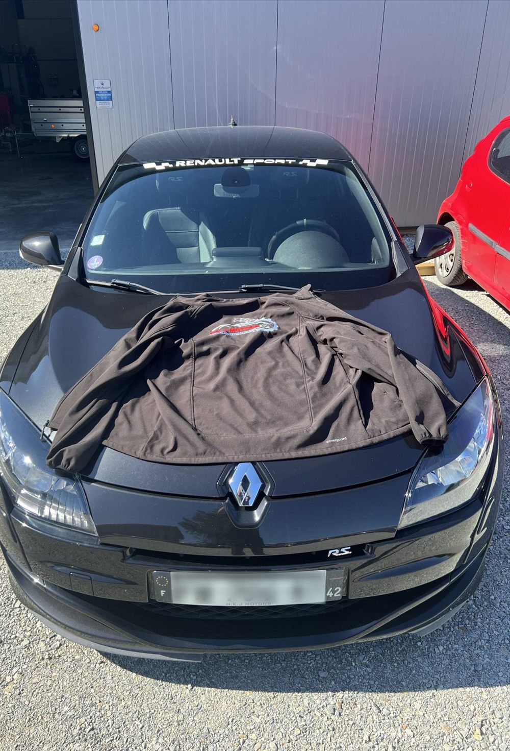 Renault Mégane R.S. noire, la veste brodée posée sur le capot