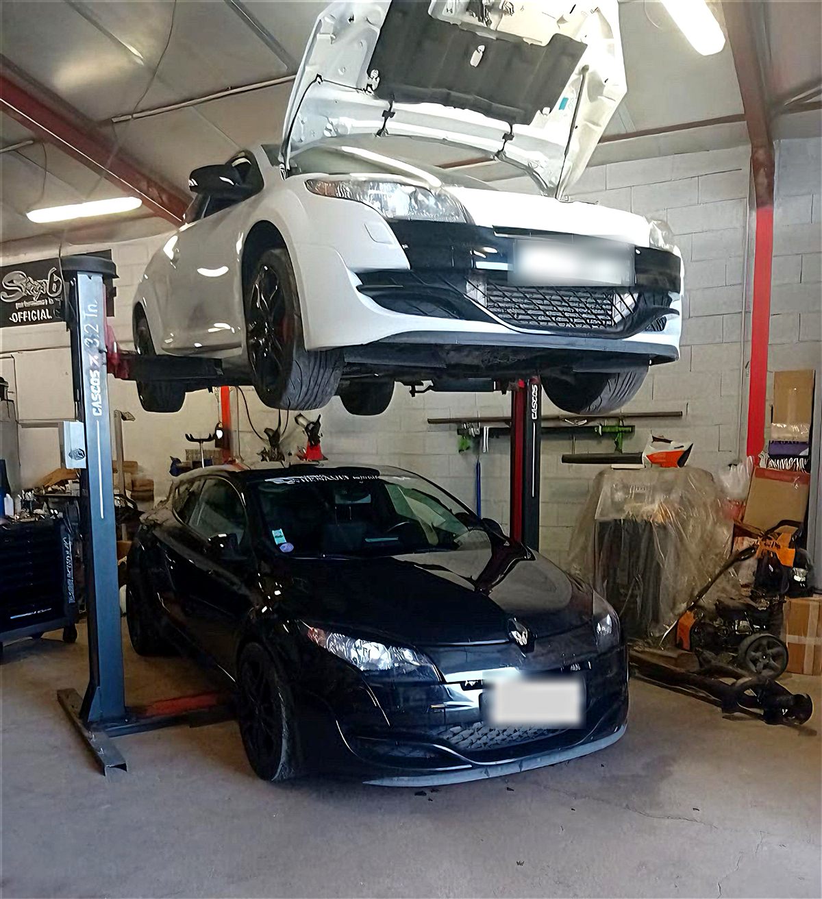 Deux Renault Mégane R.S. dans l'atelier, l'une sur le pont élévateur